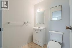 Bathroom featuring a white vanity with integrated sink, chrome faucet, and overhead lighting - 