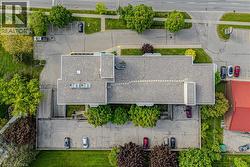 Expansive commercial building featuring a gray shingle roof and multiple rooftop units - 