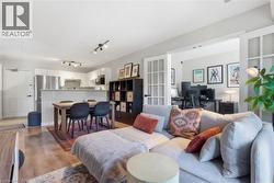 Open-concept living space with wood-finish flooring - 