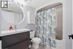 Modern vanity with integrated sink, brushed nickel faucet, and circular mirror - 