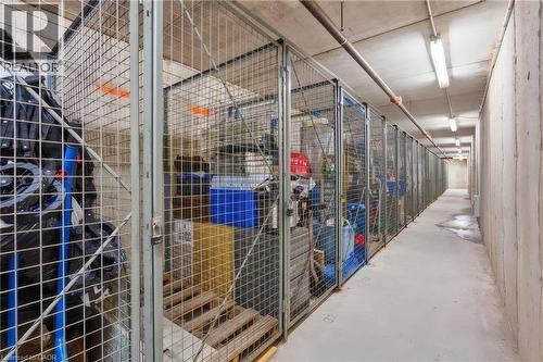 Underground parking garage featuring concrete flooring, concrete support columns, overhead lighting, and numbered parking spaces - 1421 Walkers Line Unit# 209, Burlington, ON - Indoor Photo Showing Garage