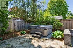 Outdoor spa with steps, set on a stone paver patio - 