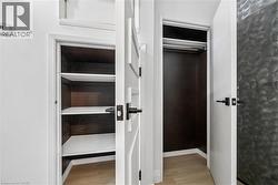 Two interior storage closets featuring white doors with dark hardware - 