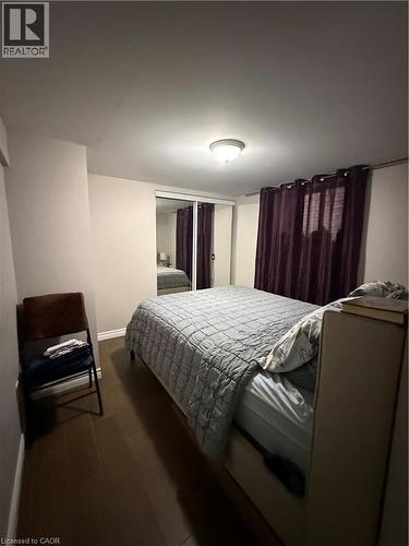 Room featuring dark wood-finish flooring, light neutral walls, and a ceiling-mounted light fixture - 947 Main Street E Unit# 6, Hamilton, ON - Indoor Photo Showing Bedroom