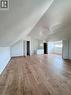Spacious attic room featuring wood-finish flooring, white walls, and a sloped ceiling - 10 Fairleigh Avenue N, Hamilton, ON  - Indoor Photo Showing Other Room 