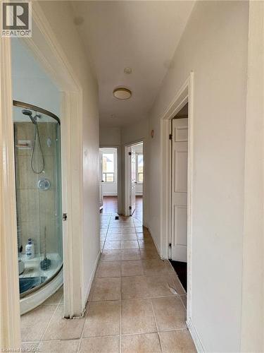 Hallway featuring light-toned square tile flooring, white walls, and a ceiling-mounted light fixture - 10 Fairleigh Avenue N, Hamilton, ON - Indoor Photo Showing Other Room