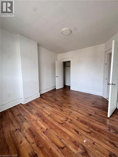 Spacious room featuring wood-finish flooring, white baseboards, and a neutral color palette - 10 Fairleigh Avenue N, Hamilton, ON - Indoor Photo Showing Other Room