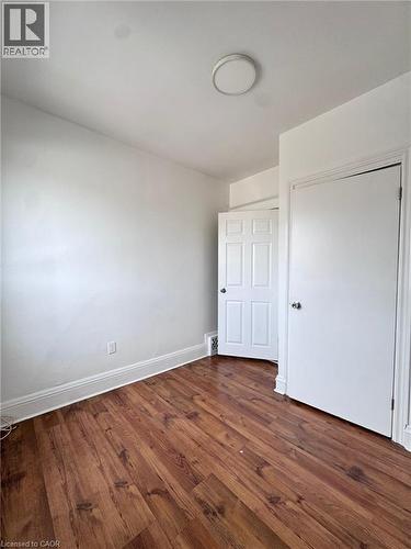 Room featuring wood-finish flooring, white walls, and a ceiling-mounted light fixture - 10 Fairleigh Avenue N, Hamilton, ON - Indoor Photo Showing Other Room