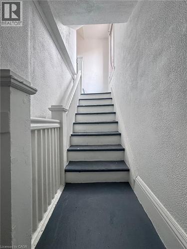 Stairwell featuring painted white risers and dark treads, white balusters, and textured wall finishes - 10 Fairleigh Avenue N, Hamilton, ON -  Photo Showing Other Room
