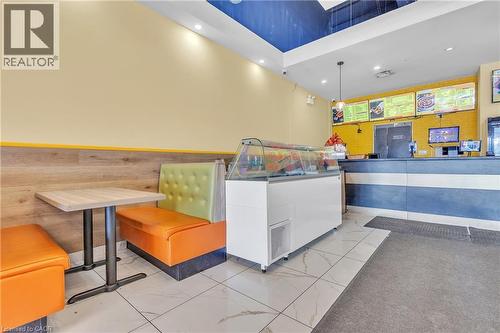 Commercial interior featuring booth seating, a service counter, and display refrigeration - 5 Manitou Drive Unit# 106B, Kitchener, ON 