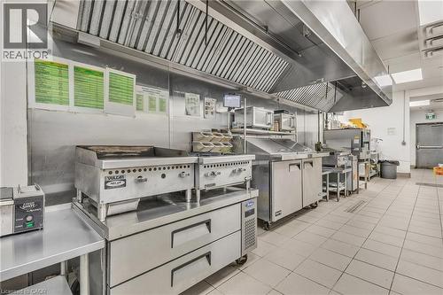 Commercial kitchen featuring stainless steel equipment and extensive counter space - 5 Manitou Drive Unit# 106B, Kitchener, ON 