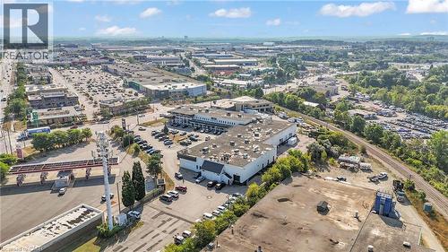 Expansive commercial property featuring a large primary building with extensive parking, surrounded by additional commercial structures and green spaces - 5 Manitou Drive Unit# 106B, Kitchener, ON 