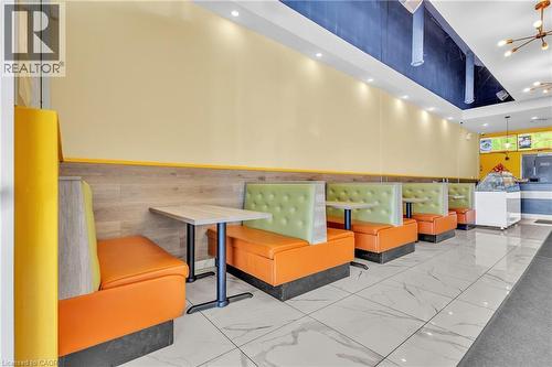 Commercial space featuring a row of booth seating, wood-finish wall paneling, and a high ceiling with recessed lighting - 5 Manitou Drive Unit# 106B, Kitchener, ON 