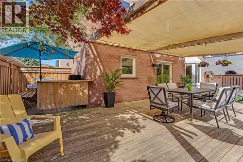 Expansive wood deck featuring a shade canopy, built-in wooden bar, and privacy fencing - 42 Handorf Drive, Cambridge, ON - Outdoor With Deck Patio Veranda With Exterior