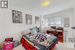 Carpeted room with a ceiling-mounted light fixture and a window featuring horizontal blinds - 