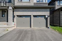 Stone facade with a double-car garage featuring individual doors and transom windows - 