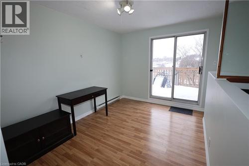 Light wood-finish flooring complements the pastel wall color in this open living space featuring a sliding glass door providing access to an exterior deck - 67 Valleyview Road Unit# 58, Kitchener, ON - Indoor Photo Showing Other Room