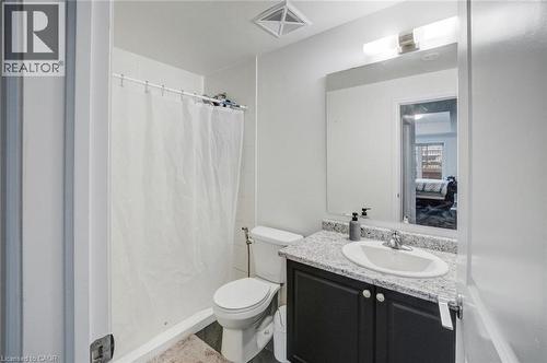Bathroom with a dark gray vanity cabinet, white oval undermount sink, and a speckled light-toned countertop - 2635 William Jackson Drive Unit# 705, Pickering, ON - Indoor Photo Showing Bathroom
