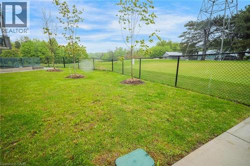 Expansive green lawn featuring newly planted trees, a black chain-link fence, and a concrete perimeter - 2635 William Jackson Drive Unit# 705, Pickering, ON - Outdoor