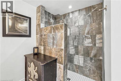 Walk-in shower featuring multi-toned tile surround and a tiled floor - 937 Park Avenue W, Burlington, ON 
