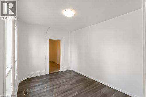 Room with wood-finish flooring, white walls, and a recessed doorway - 87 Lancaster Street W, Kitchener, ON - Indoor Photo Showing Other Room