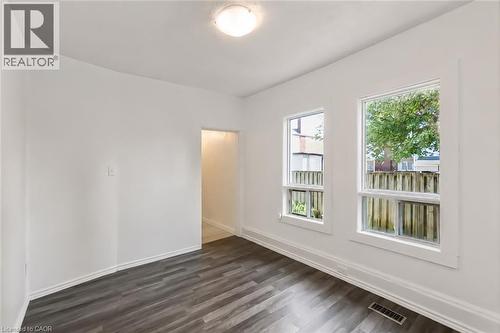 Bright interior space featuring white walls, dark wood-finish flooring, and white trim - 87 Lancaster Street W, Kitchener, ON - Indoor Photo Showing Other Room