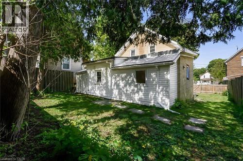 Expansive backyard featuring a grass lawn, mature trees, and a wooden privacy fence - 87 Lancaster Street W, Kitchener, ON - Outdoor