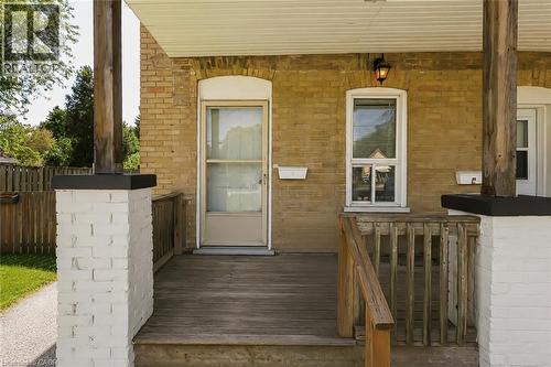 Inviting front porch featuring a wood deck, wood railings, and painted brick columns - 87 Lancaster Street W, Kitchener, ON - Outdoor With Exterior