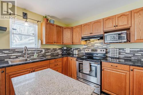 Clean oak cabinetry and modern backsplash - 3301 Ross Avenue, Cornwall, ON - Indoor Photo Showing Kitchen With Double Sink