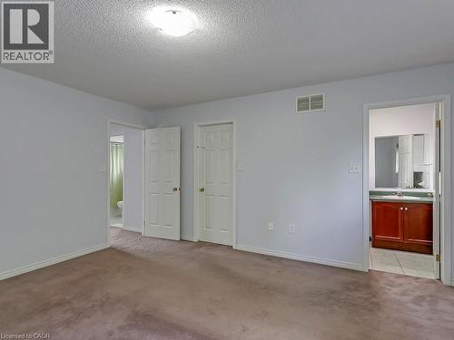 Room featuring textured ceiling, flush mount lighting, two panel doors, and brown carpeting - 1310 Blanshard Drive, Burlington, ON - Indoor Photo Showing Other Room