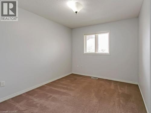 Carpeted room featuring light gray walls, a ceiling-mounted light fixture, white trim, and a window with white framing - 1310 Blanshard Drive, Burlington, ON - Indoor Photo Showing Other Room