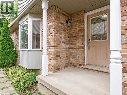 Brick facade home featuring a bay window, decorative glass entry door, concrete front porch, and white columns - 1310 Blanshard Drive, Burlington, ON - Outdoor With Exterior