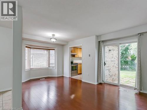 Spacious living area featuring polished wood-finish flooring and a contemporary overhead light fixture - 1310 Blanshard Drive, Burlington, ON - Indoor