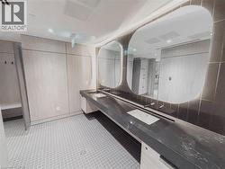 Dual vessel sinks integrated into a dark countertop, complemented by modern wall-mounted faucets - 