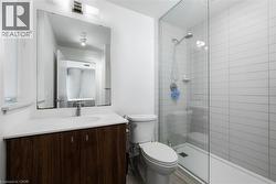 Bathroom with vanity, toilet, and tiled shower - 