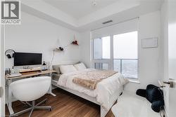 Bedroom with hardwood / wood-style floors and a tray ceiling - 