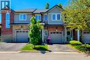 Townhome exterior featuring brick and stone cladding, light-colored siding, multiple windows with white frames, individual garage doors, and landscaped front yards - 232 Stonehenge Drive Unit# 2, Ancaster, ON  - Outdoor With Facade 