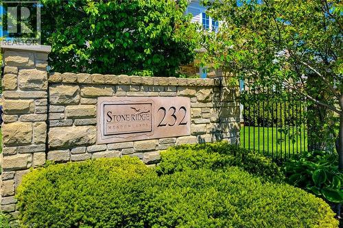 Stacked stone wall with a carved ""Stone Ridge Meadowslands"" sign and property number 232 - 232 Stonehenge Drive Unit# 2, Ancaster, ON - Outdoor