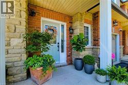 Brick and stone facade featuring a light blue entry door with clear glass panels, a concrete porch, and a white framed window with muntins - 