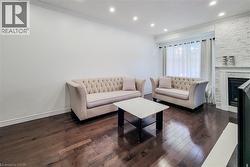 Living area featuring dark wood-finish flooring, recessed lighting, and crown molding - 