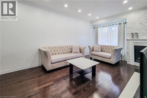 Living area featuring dark wood-finish flooring, recessed lighting, and crown molding - 232 Stonehenge Drive Unit# 2, Ancaster, ON - Indoor Photo Showing Living Room With Fireplace