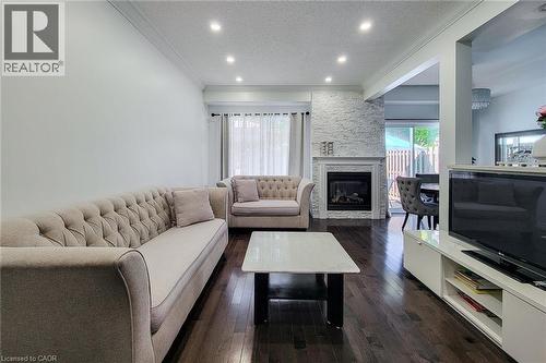 Living area with dark wood-finish flooring and recessed lighting - 232 Stonehenge Drive Unit# 2, Ancaster, ON - Indoor Photo Showing Living Room With Fireplace
