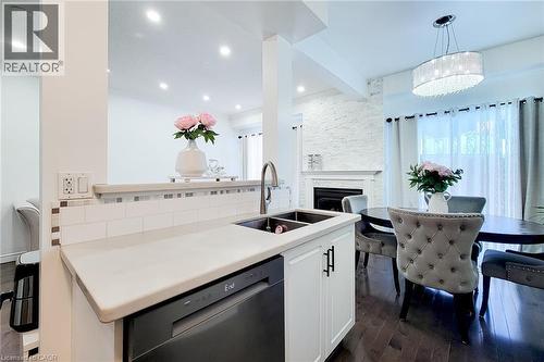 Kitchen peninsula with a double basin sink and integrated dishwasher - 232 Stonehenge Drive Unit# 2, Ancaster, ON - Indoor Photo Showing Kitchen With Double Sink