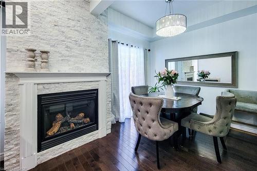 Fireplace with a stacked stone surround and a classic white mantel - 232 Stonehenge Drive Unit# 2, Ancaster, ON - Indoor With Fireplace