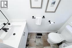 Bathroom featuring a white vanity with an integrated sink, matte black hardware, and patterned floor tiles - 
