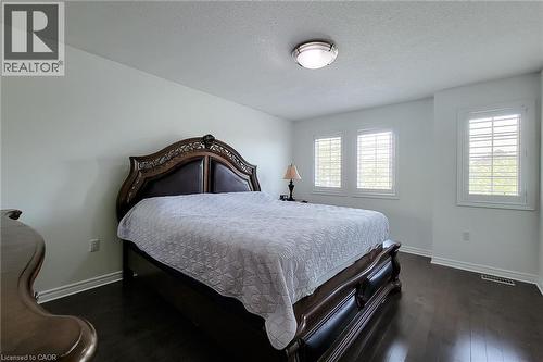 Spacious room featuring dark wood-finish flooring and light-toned walls - 232 Stonehenge Drive Unit# 2, Ancaster, ON - Indoor Photo Showing Bedroom