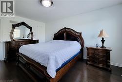 Spacious room featuring dark wood-finish flooring, white walls, and a recessed ceiling light - 