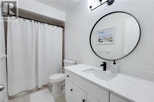 Bathroom featuring a white vanity with integrated sink, white countertop, and matte black faucet - 232 Stonehenge Drive Unit# 2, Ancaster, ON - Indoor Photo Showing Bathroom