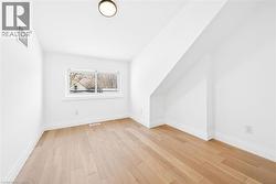 Additional living space featuring light wood-style floors and vaulted ceiling - 