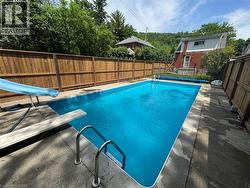 Outdoor rectangular swimming pool with integrated diving board and slide - 